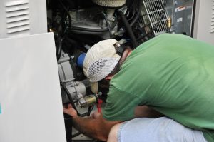 Man Repairing the Inside of a Generator