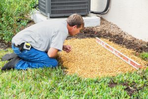 man checking foundation for generator